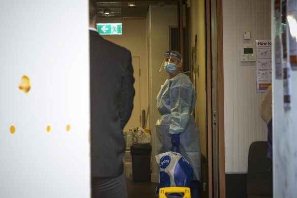 A worker dressed in PPE inside a Melbourne CBD hotel on Sunday.