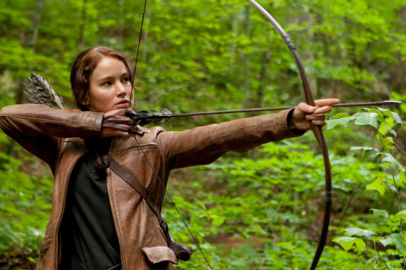 A tendril of hair dances on her forehead as Jennifer Lawrence takes aim as Katniss Everdeen in The Hunger Games.