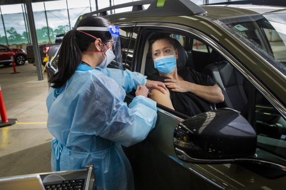 Health worker Khanh Tran  gives Nicolette Kolozsi her first Pfizer jab at the drive-through clinic in Melton.

