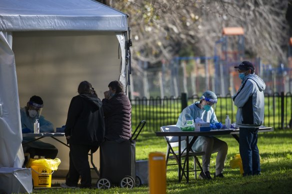 Residents from the Racecourse Road public housing towers line up for testing on Sunday morning.