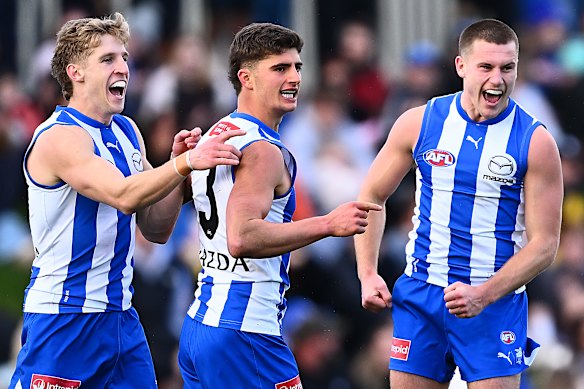Harry Sheezel celebrates kicking a goal with teammates.