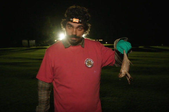 Tony Armstrong holds a cane toad in the ABC documentary series Eat the Invaders.