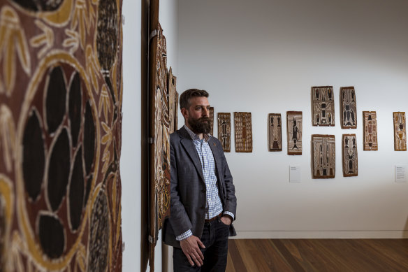 Curator Ben Thomas at Trinity College with the bark paintings.