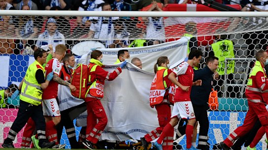 Denmark’s Christian Eriksen is taken away on a stretcher after collapsing on the pitch during the Euro 2020 soccer championship group B match between Denmark and Finland.