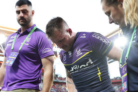 Cameron Munster limps from the Suncorp Stadium turf.