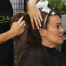 Hairdresser Joanne Sultana works on Sonia Korthout's hair at Union Jacks Hair salon in Frenchs Forest on Wednesday.