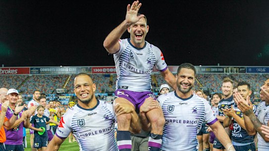 Storm captain Cameron Smith is chaired off the field by William Chambers (left) and Jesse Bromwich after the Round 5 NRL match between the North Queensland Cowboys and the Melbourne Storm.