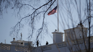 Members of the Secret Service look out from atop the White House on Sunday.