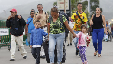 Venezuelan migrant mother Yelitza Fuenmayor crosses the Simon Bolivar International Bridge into Colombia with her children and luggage.