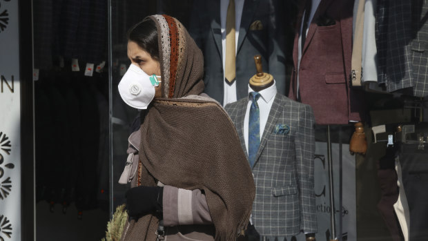 A woman walks as she wears a mask in  Tehran, Iran.