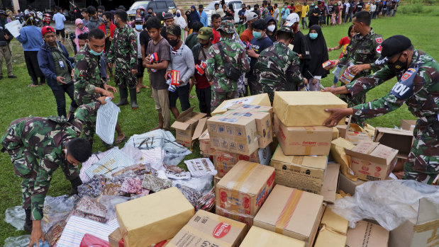 Indonesian soldiers distribute aid for those affected by the earthquake at a stadium in Mamuju on Sunday.