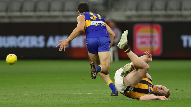 The Hawks defender clutches his knee after going down in a contest against West Coast's Tom Barrass.