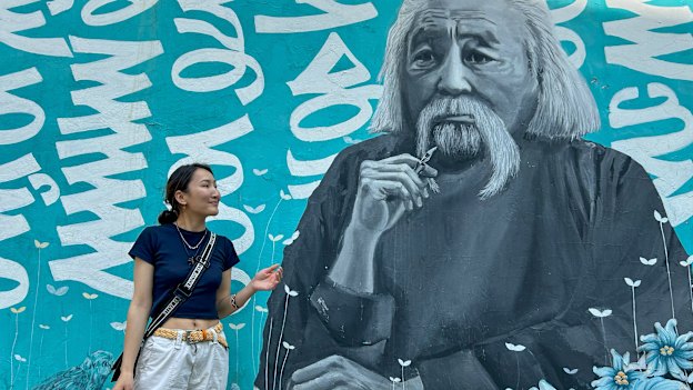 Zolzaya Nyamdorj, a coordinator at Save the Mongolian Language movement, in front of a mural of scholar Renchin Byamba. 