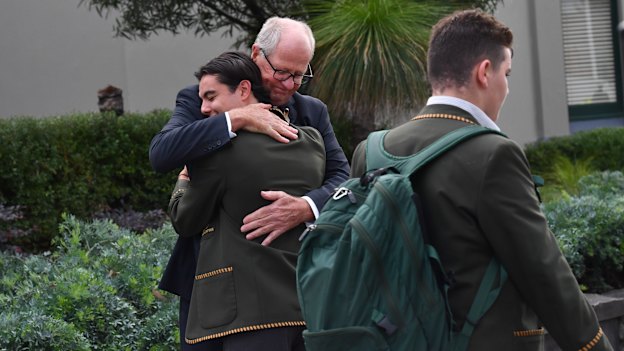 Rohan Brown hugs students upon his return to the school.