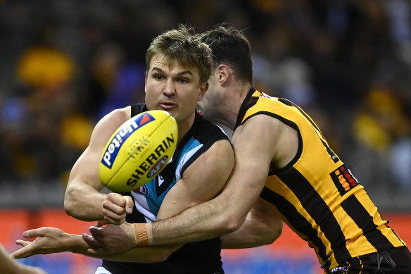 Port Adelaide’s Ollie Wines handballs while being tackled.