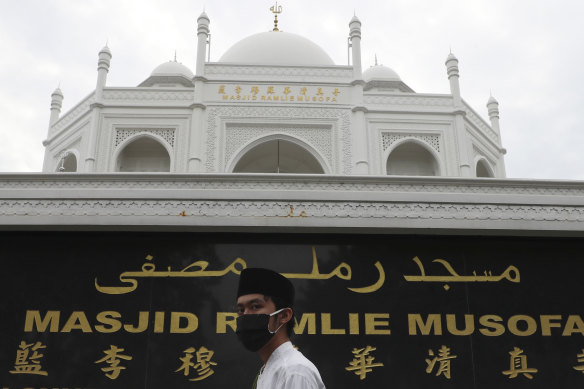 A man walks past the Ramlie Musofa mosque in Jakarta.