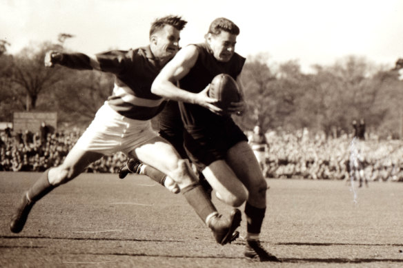 Ron Barassi attempts to shake a tackle for Melbourne in their 1954 VFL grand final loss to Footscray.