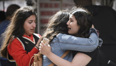 Friends embrace after shots were fired at the championship parade.