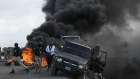 Police abandon their vehicle during a demonstration that turned violent in Cap-Haitien on Thursday.