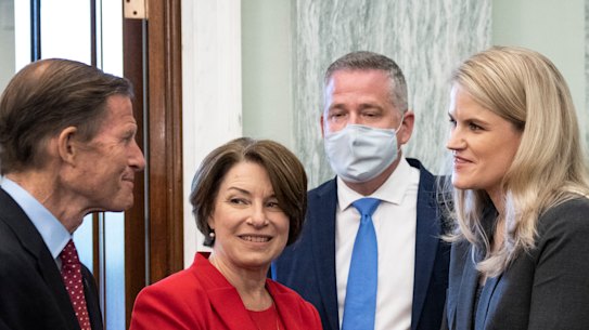Democrat Senators Richard Blumenthal, left, and Amy Klobuchar speak with former Facebook employee and whistleblower Frances Haugen, right, as she arrives to testify in the Senate in Washington. 