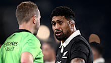 Referee Angus Gardner talks with Ardie Savea of New Zealand.