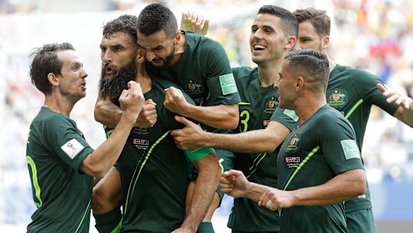 Composed: Mile Jedinak is congratulated after scoring.