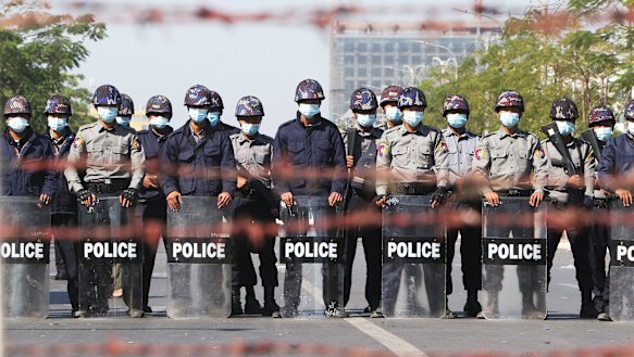 Police officers stand in a road blocking protesters during a demonstration in Mandalay.