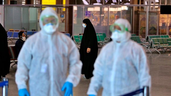 Medical staff prepare to check passengers arriving from Iran in the airport in Najaf, Iraq.