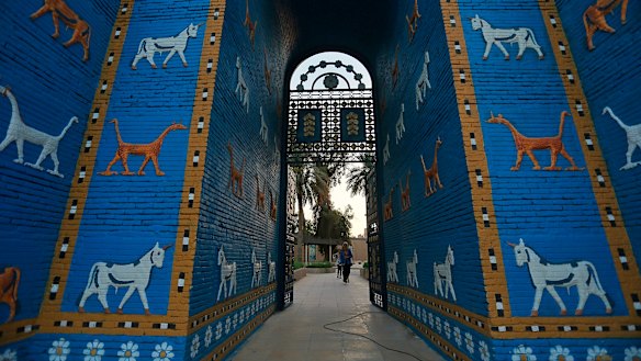 People walk near the replica Ishtar Gate the archaeological site of Babylon, Iraq, on Friday.