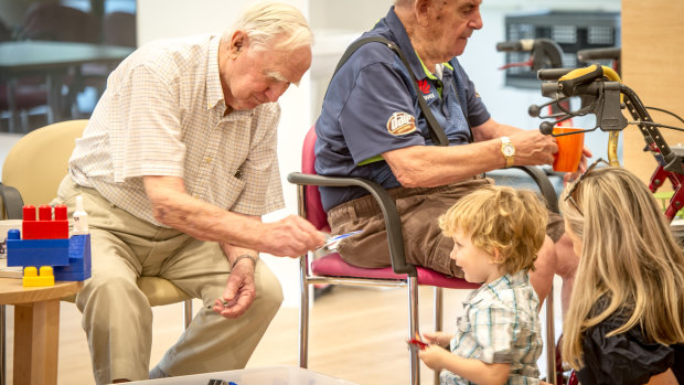Participants of Intergenerational Playgroup, a scheme where residents of the Miranjani retirement village interact with kids from a local playgroup on a weekly basis to boost mental health and physical health.  Ex-pilot Ken Huttan (left) and Ron Dean (right) regularly play aeroplanes with three year old Archie Tunningley. 