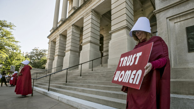 Michelle Disher and others dressed as characters from The Handmaid's Tale protest outside the Georgia Capitol.