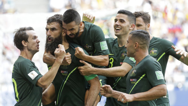Captain courageous: Mile Jedinak is mobbed by teammates after nervelessly converting from the spot in Russia.