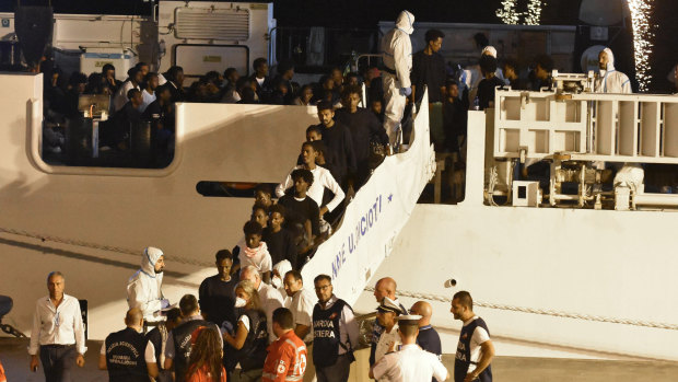 Migrants disembark from the Italian Coast Guard ship "Diciotti" in the port of Catania, Italy, on Sunday.