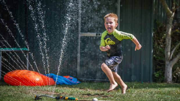 Cooper Bond, 5, of Jerrabomberra plays with water in the backyard earlier in January in a bid to cool off.