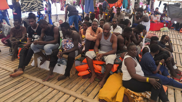 Migrants wait aboard the Open Arms Spanish humanitarian boat in the Mediterranean sea.