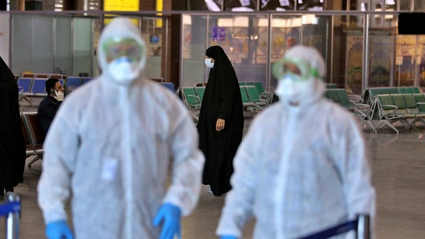 Medical staff prepare to check passengers arriving from Iran in the airport in Najaf, Iraq.