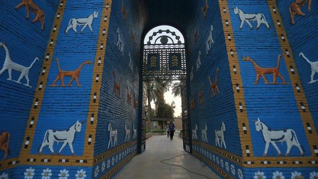 People walk near the replica Ishtar Gate the archaeological site of Babylon, Iraq, on Friday.
