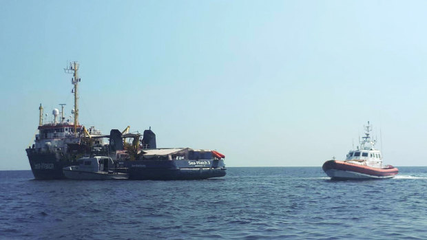 An Italian Coast Guard boat patrols next to the Sea-Watch 3 vessel, in the Mediterranean Sea just off the coasts of the southern Italian island of Lampedusa  before the ship docked.