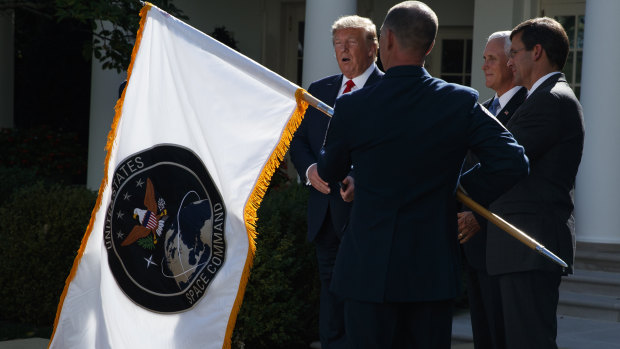 US President Donald Trump watches as the flag of the new US Space Command is presented.