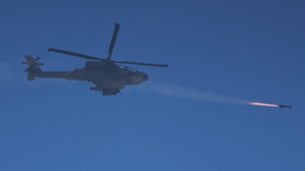 An Israeli Apache helicopter fires a missile.