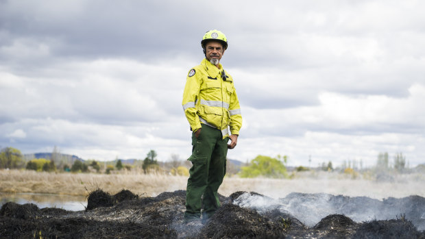 Aboriginal fire project officer Dean Freeman stands on top of burnt grassland during a cultural and ecological burn at the Jerrabomberra Wetlands.