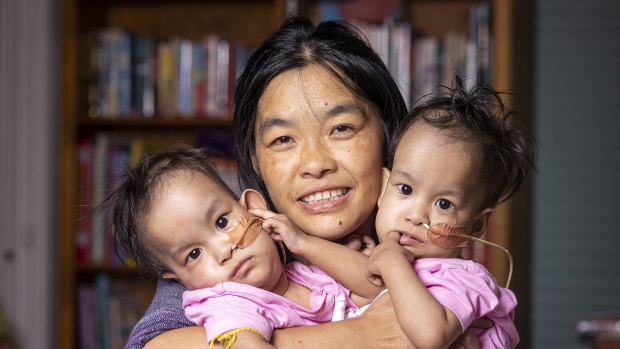 Bhumchu Zangmo hugs her twin girls Nima and Dawa.