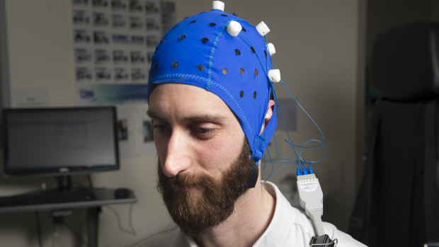 University of Canberra assistant professor Andrew Flood demonstrates the transcranial direct current stimulation device used to deliver electric current to the brain. 