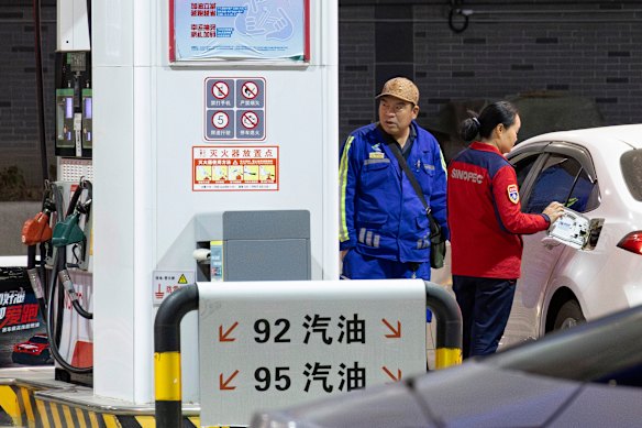 Um cliente observa o medidor de combustível enquanto seu tanque é abastecido em um posto de gasolina SINOPEC no distrito de Tongzhou, no leste de Pequim.