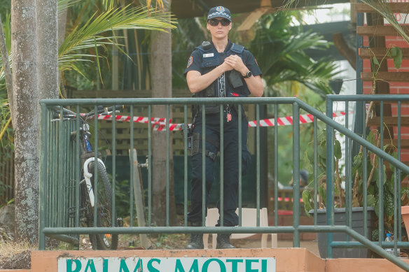 A policewoman stands guard outside the Palms Motel in Darwin.