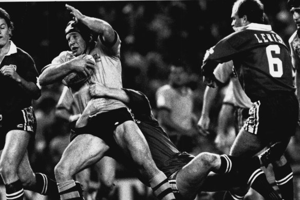 New South Welshman Bruce McGuire takes the ball up during the Queensland vs N.S.W. State of Origin game at Sydney's Sport Centre, 1989. Wally Lewis at right.