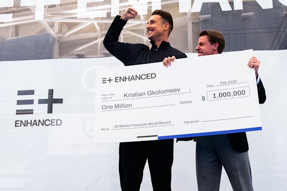 Swimmer Kirstian Gkolomeev picks up his cheque for $US1 million after breaking the men’s 50m freestyle world record as part of an Enhanced Games documentary.