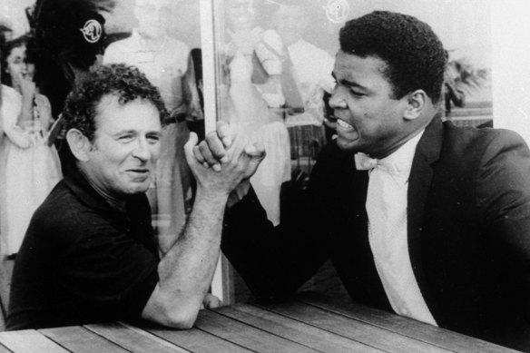 Novelist Norman Mailer arm wrestles with heavyweight champion Muhammad Ali in 1965.