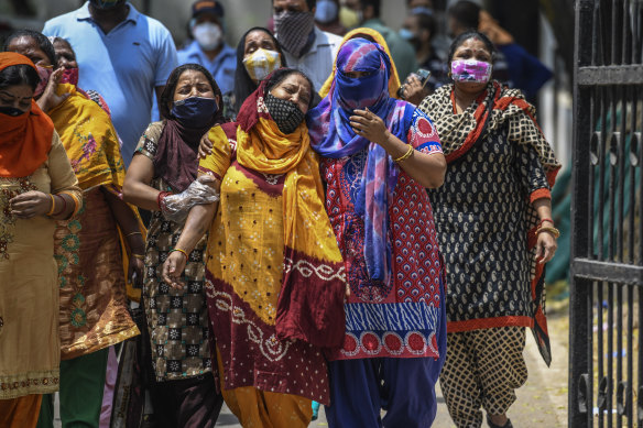 Distraught women outside a New Dehli hospital. Coronavirus cases and deaths in India are rising.