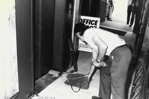 A policeman points to equipment left by robbers at the Haymarket branch of the National Australia Bank. The heist was described by police as professional and “extremely well planned”.